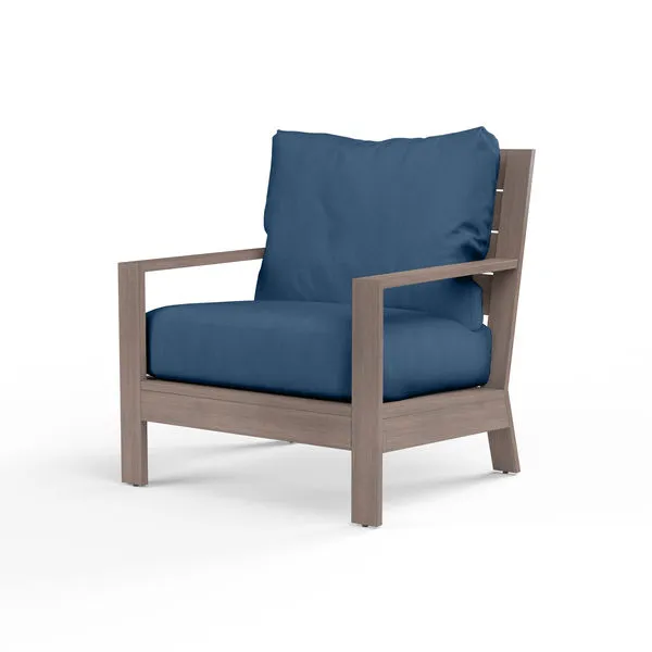 Laguna Club Chair with aluminum frame in driftwood finish and blue cushions with thick seat and back pillows