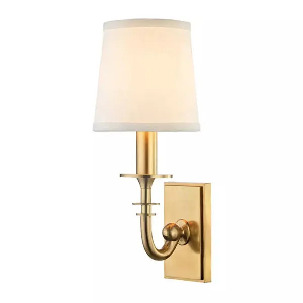 Brass wall sconce with small rectangular backplate, curved arm, and white fabric tapered lampshade