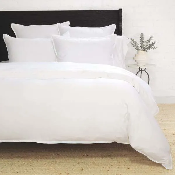 Langston Bamboo Sateen Duvet Set in white on a queen bed with multiple pillows and a textured rug