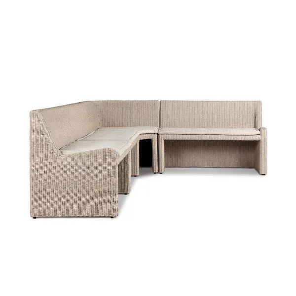 L-shaped vintage white outdoor dining banquette in rattan with fabric cushions and soft curved lines