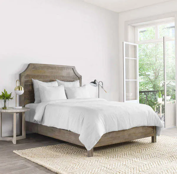 Jayson Linen Cashmere White Duvet on wooden bedframe in bright room with natural light and woven rug