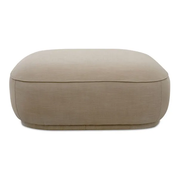 Beige Marion Square Ottoman with plump curved design, detailed piping, and recessed base for floating look