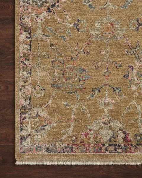 Close-up corner of Giada Gold / Multi Rug on dark wood floor showing pile texture and faded classic motifs