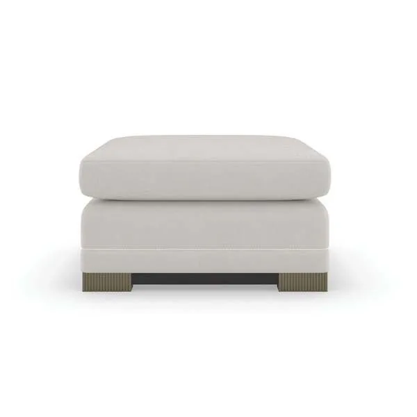 Square ottoman fully upholstered in light textured chenille with braided leather welt, fluted silver shadow legs, and dark...