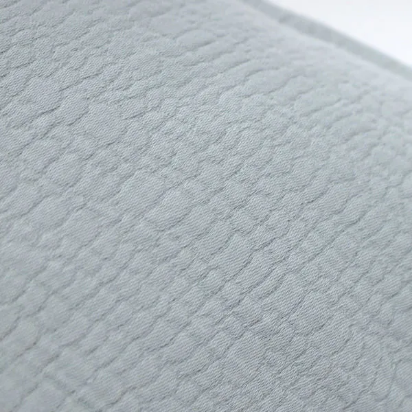 Detailed close-up of the wavy pebbled texture on the light gray cotton duvet fabric