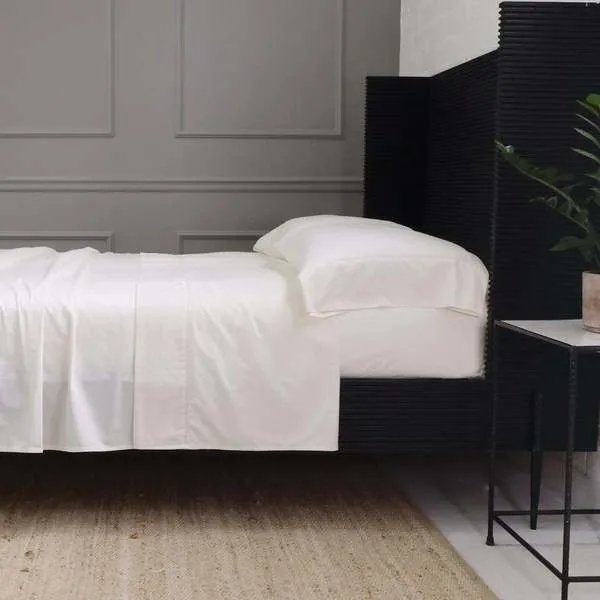 Ivory Classico Hemstitch cotton sateen pillowcase on king bed with matching sheets in modern bedroom