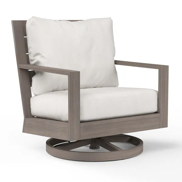 Laguna Swivel Club Rocker with driftwood-finish aluminum frame and plush off-white cushions