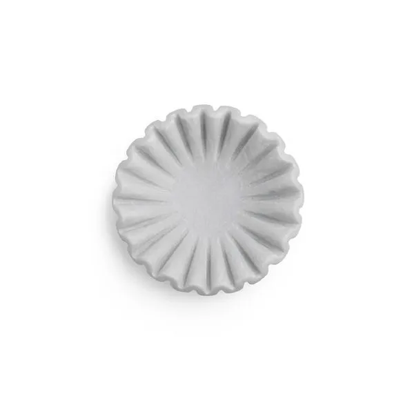 Small white marble bowl with soft ruffled edges and smooth finish, viewed from above