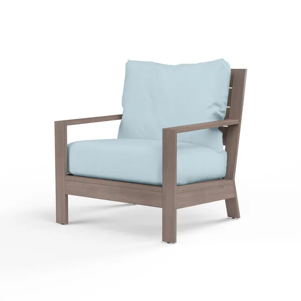 Laguna Club Chair with hand-brushed aluminum frame resembling driftwood and pale blue outdoor cushions
