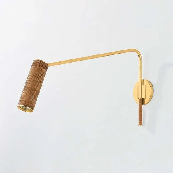Narragansett Wall Sconce with aged brass finish and cylindrical rattan-wrapped shade on an elongated swing arm