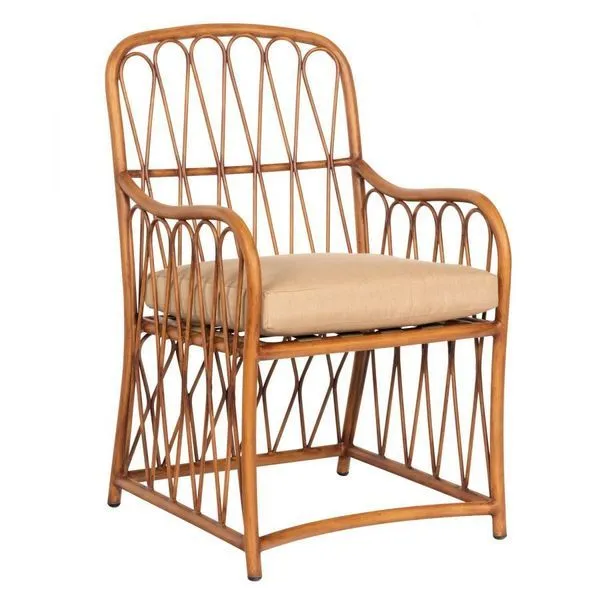 Outdoor dining arm chair with cane-style aluminum frame and beige cushioned seat