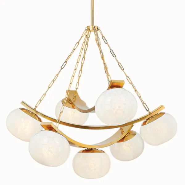 Chandelier on white background with six seeded glass globes hanging from gold chains and curved gold metal frame