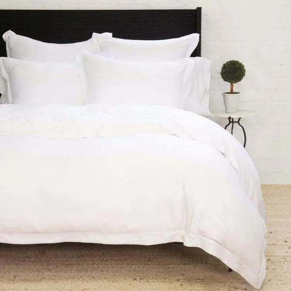 Sheena Bamboo Sateen Duvet Set on king bed with crisp white smooth fabric and multiple matching pillows