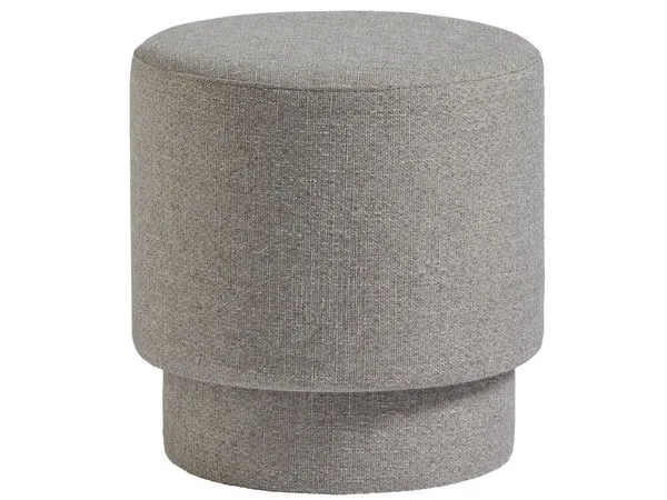 Round Reyes Ottoman in light textured gray upholstery with a tiered, cylindrical silhouette