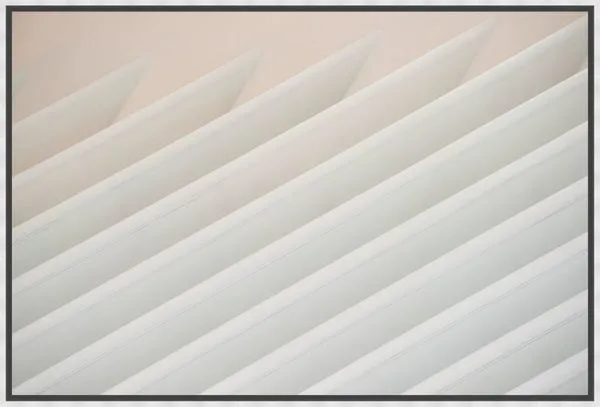 Photographic artwork featuring angled, overlapping white panels with geometric lines and shadows on a soft gradient backgr...