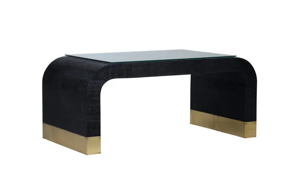 Waterfall Coffee Table with black raffia covering, curved edges, antique brass feet, and removable glass top