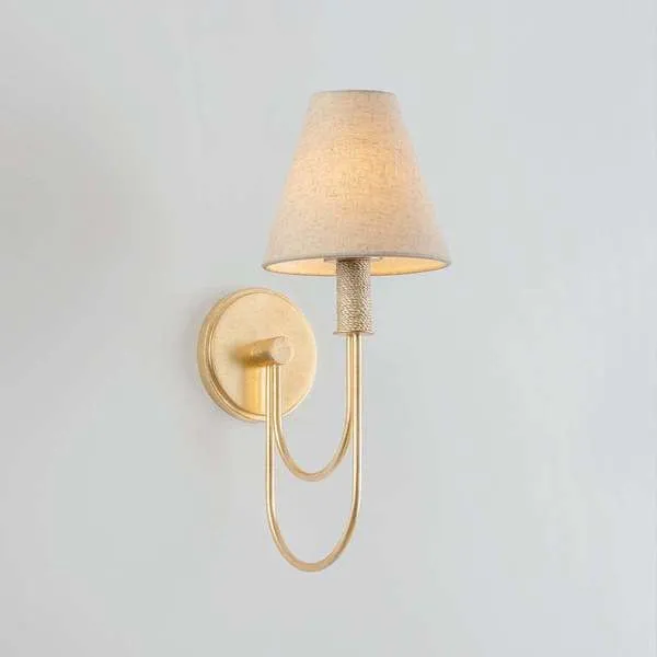 Warrensburg Wall Sconce shown fully lit on a light gray wall in a front side view