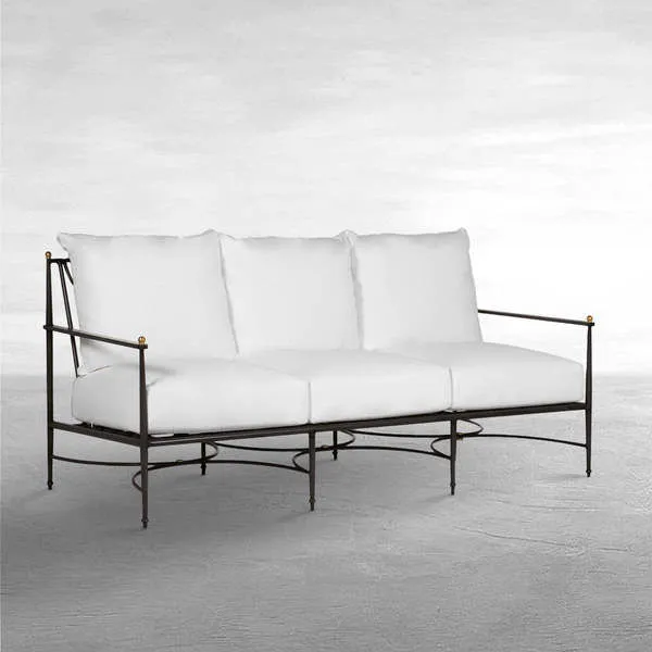 Roma Aluminum Outdoor Sofa with white plush cushions, black aluminum frame, and brass accent finials