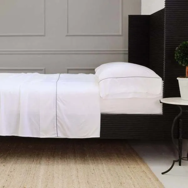 Queen bed dressed in white Sheena Bamboo Sateen Sheet Set with smooth bamboo fabric and neatly tucked corners