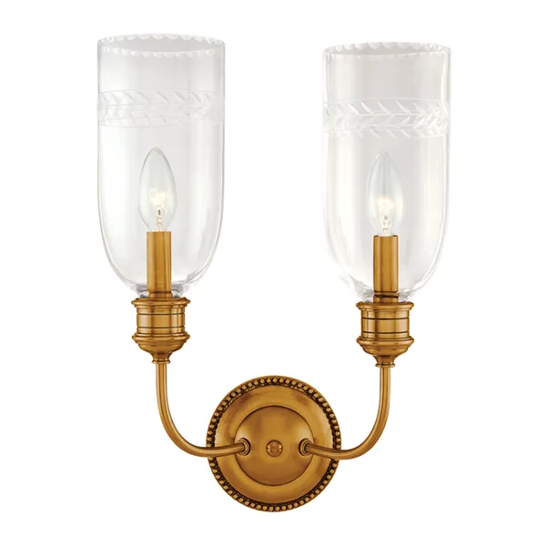 Two-light wall sconce with tall etched glass shades featuring scalloped edges and a round beaded brass backplate