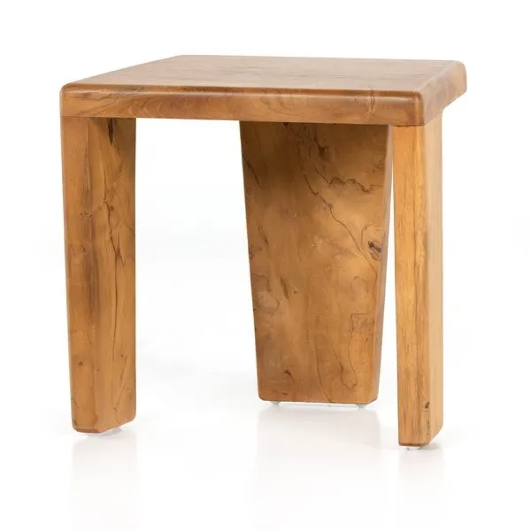 Compact outdoor accent stool in aged natural teak with a modern angular three-legged design