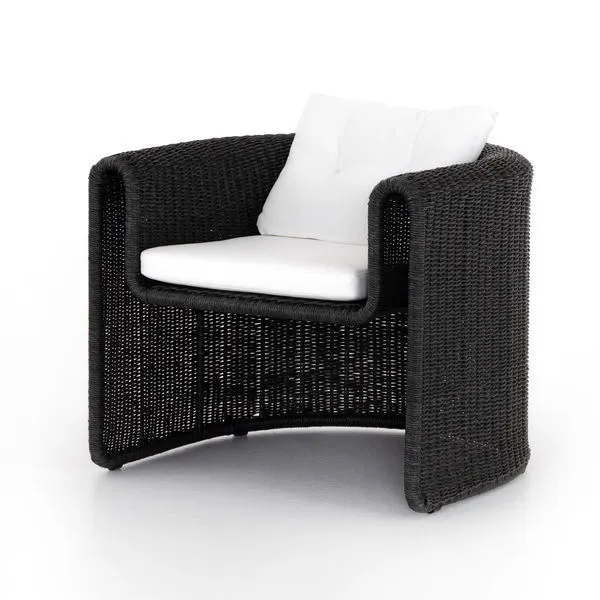 Coal-colored woven outdoor chair with curved Seventies-inspired frame and white tufted cushions