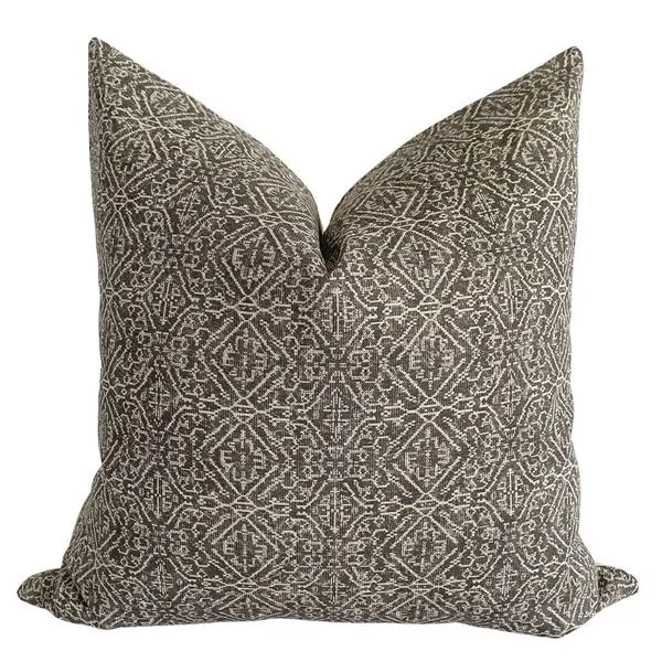 Square pillow with tan patterned linen fabric on a brownish gray background