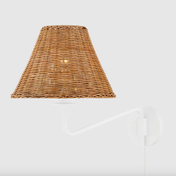 Sconce mounted with white arm and natural rattan shade visibile from side on white background