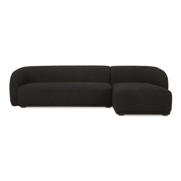 Faye sectional sofa in black boucle with curved back, firm fixed bench seat, and rounded rubberwood legs