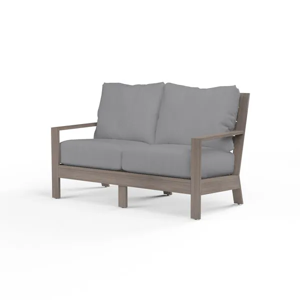 Laguna Loveseat outdoor sofa with hand-brushed driftwood finish aluminum frame and gray seat and back cushions
