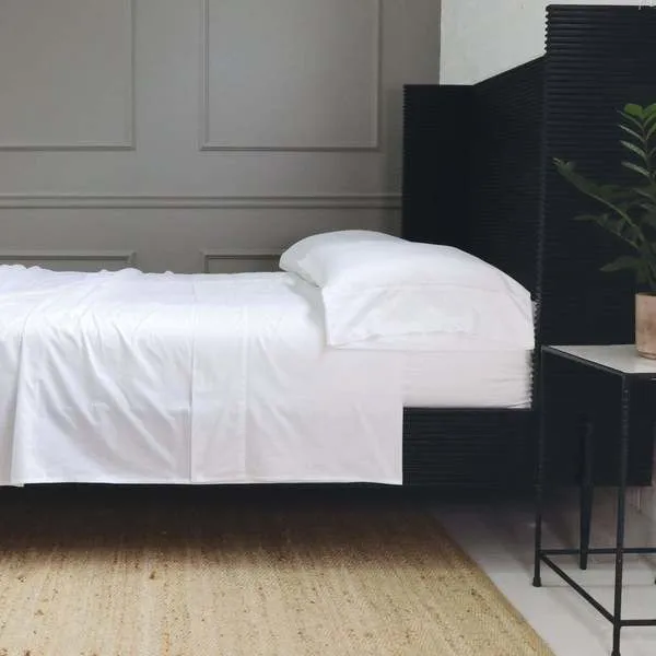 White Classico Hemstitch Cotton Sateen Sheet Set styled on a Twin bed with pillowcase and flat sheet