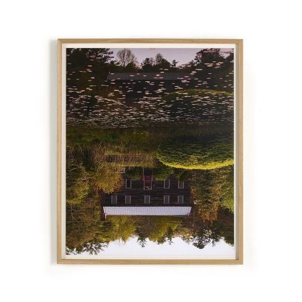 Vertical grain white oak framed photograph showing a dark rustic house reflected in a pond with floating lily pads