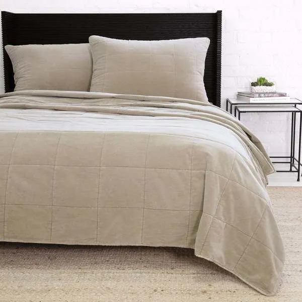 Twin-sized Amsterdam Coverlet in classic taupe with subtle quilted squares on a bed with matching pillow shams