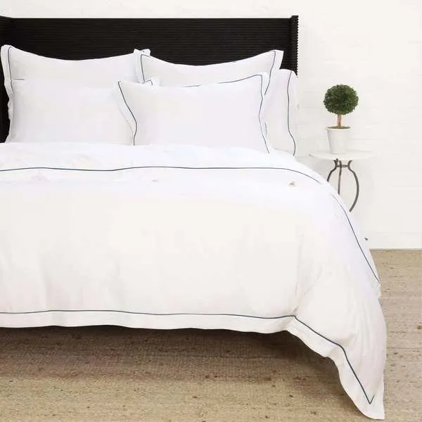 Sheena Bamboo Sateen Duvet Set in white with navy border on twin bed with matching pillow shams