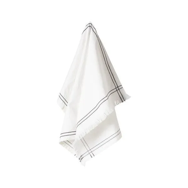 Soft white cotton kitchen towel with black embroidered border lines and fringed edges, hanging loosely
