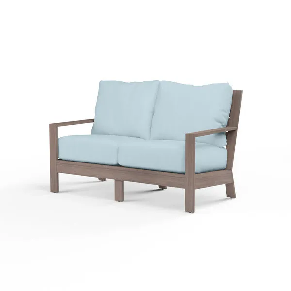 Laguna loveseat with aluminum frame finished to resemble driftwood, featuring light blue seat and back cushions