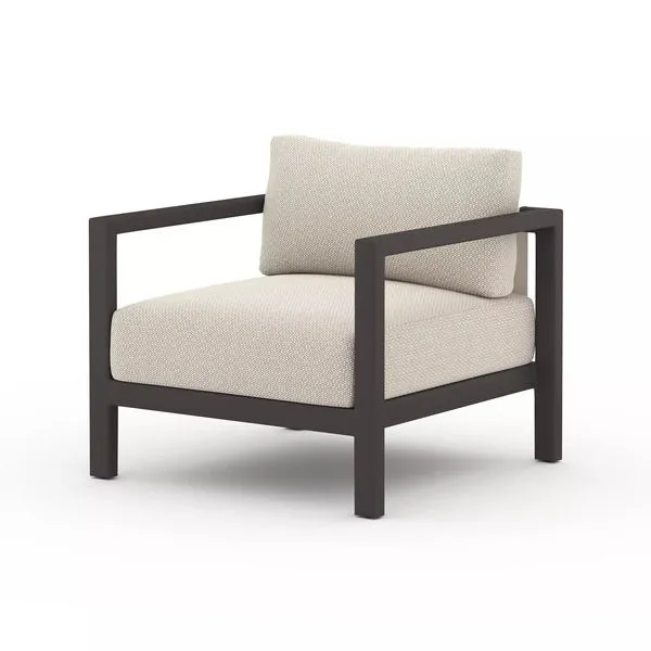 Sonoma Faye Sand Outdoor Chair with wide dark aluminum frame and deep neutral textured cushions