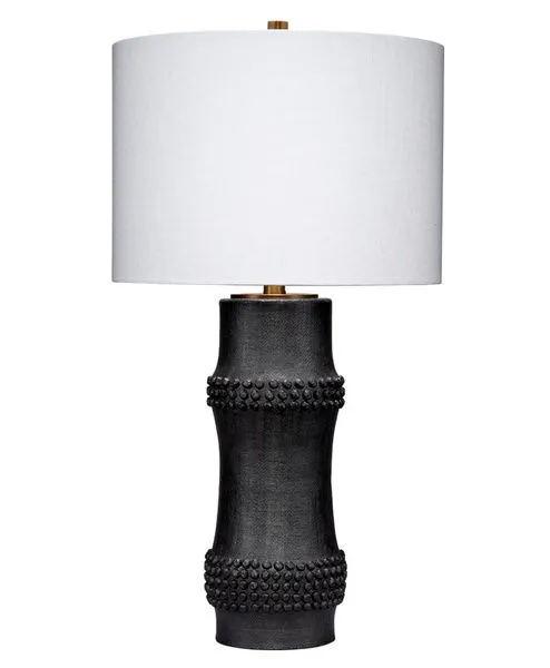 Black resin table lamp with a bamboo cane-inspired body and beaded embellishments, topped with a white linen drum shade