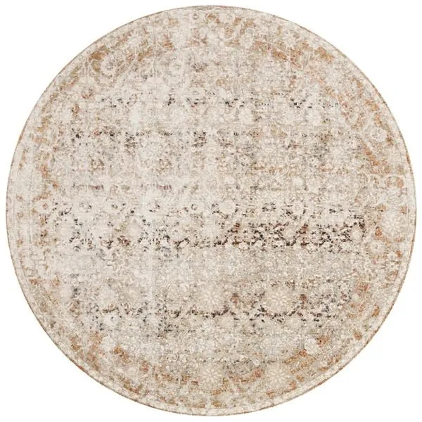 Round version of Theia Natural Rust Rug displaying ornate floral and geometric pattern in beige and rust tones