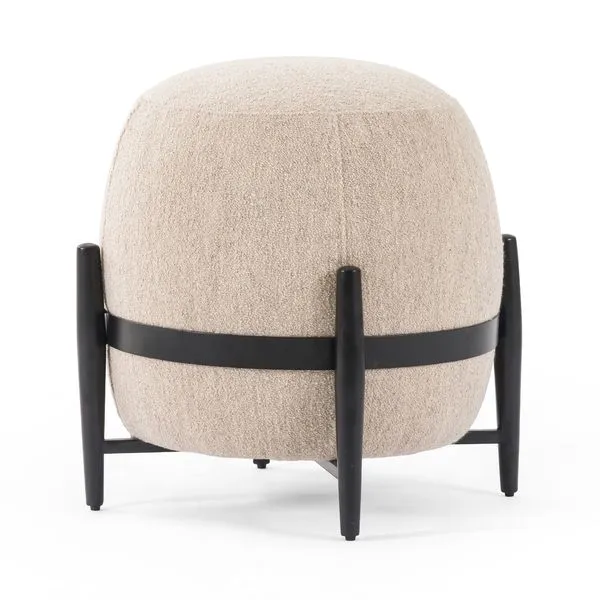 Round Sia Ottoman in beige bouclé fabric with black wooden legs and band around middle