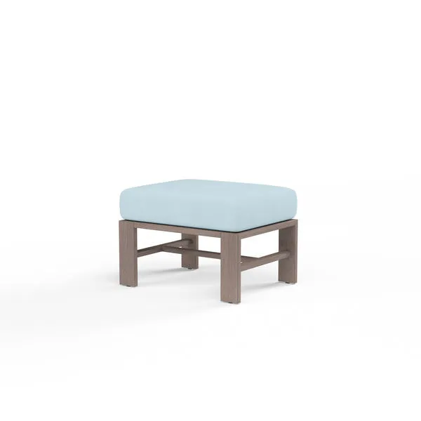 Outdoor Laguna Ottoman with driftwood-finish aluminum frame and light blue plush 6-inch cushion