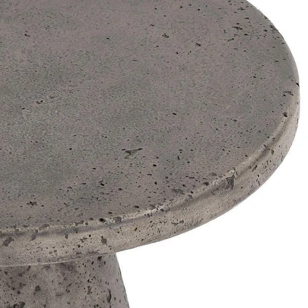 Dark gray outdoor accent table with a curved base and round textured concrete top with subtle gleam
