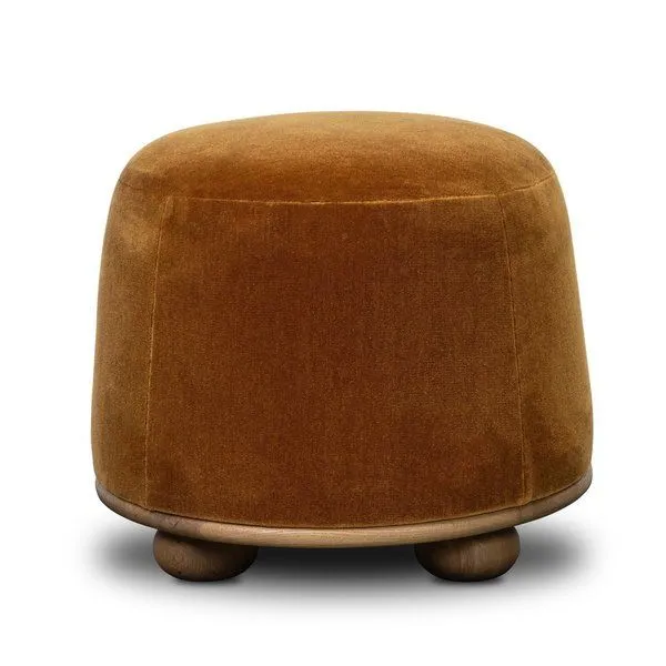 Rounded Bilbury Ottoman with plush rust-colored upholstery and wooden base with ball-shaped legs