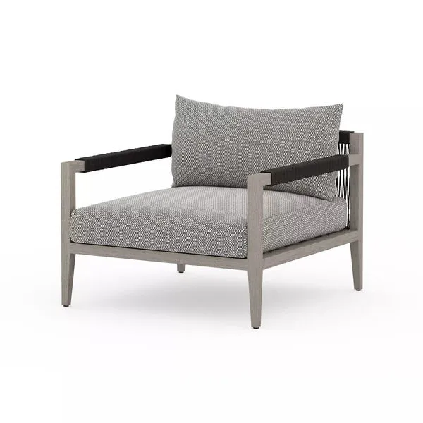 Outdoor chair with weathered grey teak frame and textured ash Sunproof fabric cushions in grey