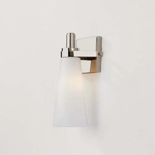 Side angle of Trude Wall Sconce showing lit opal shade and sleek metal arm detail