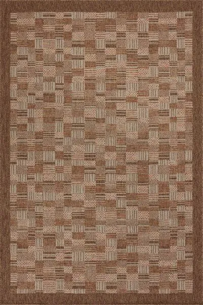 Indoor/outdoor area rug in warm rust tones with a geometric block pattern and solid border