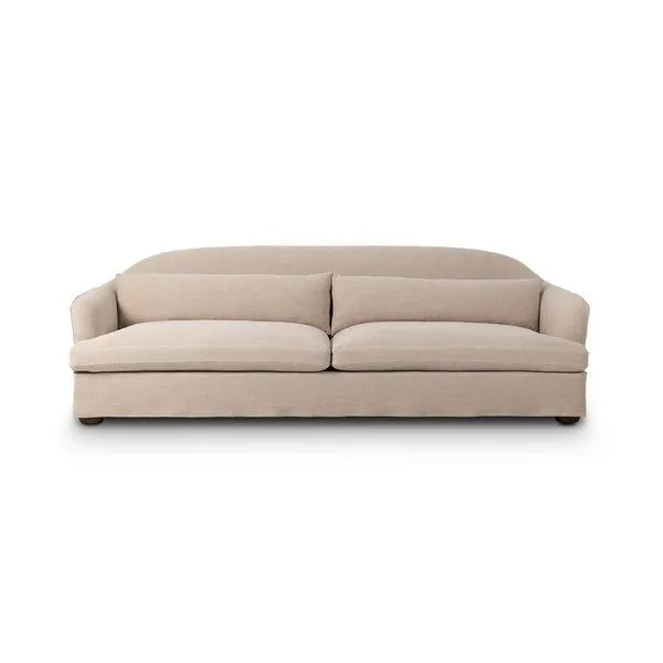 Karissa Sofa in beige slipcover with soft curves, slightly flared arms, and feather blend cushions