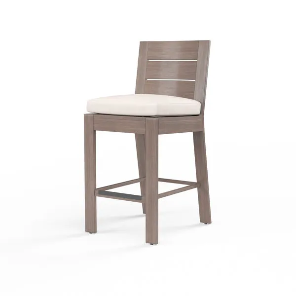 Laguna Barstool with hand-brushed aluminum frame mimicking driftwood and a light beige cushioned seat