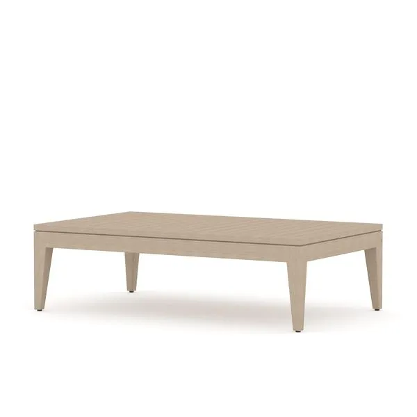 Solid teak outdoor coffee table in washed brown finish with rectangular slatted top and angled legs.