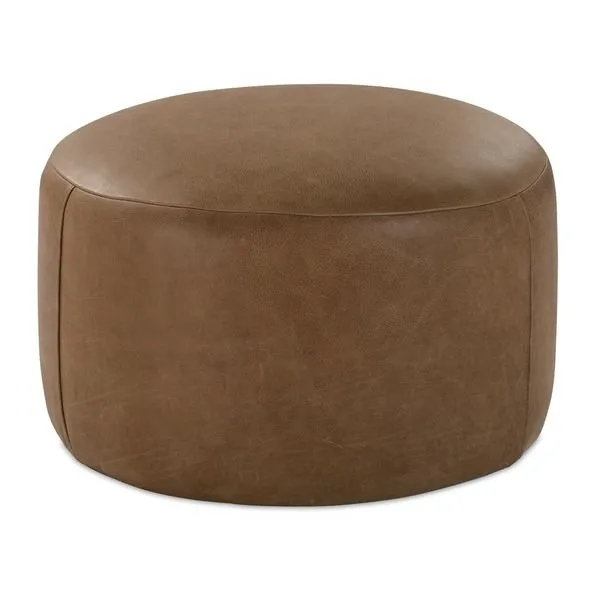 Round tan leather ottoman with smooth surface and stitched seams, low profile accent pouf